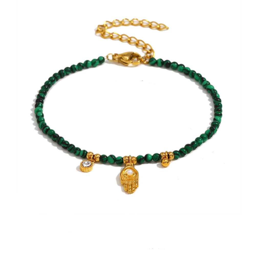 Green beaded bracelet with gold hand charms on a white background.