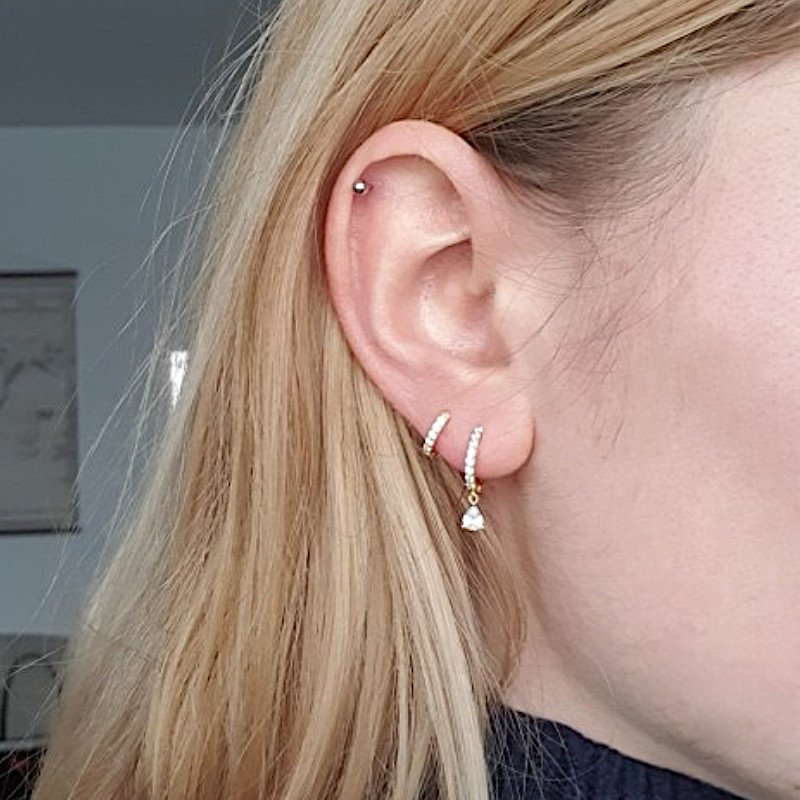 A model wearing the CZ teardrop gold huggies.