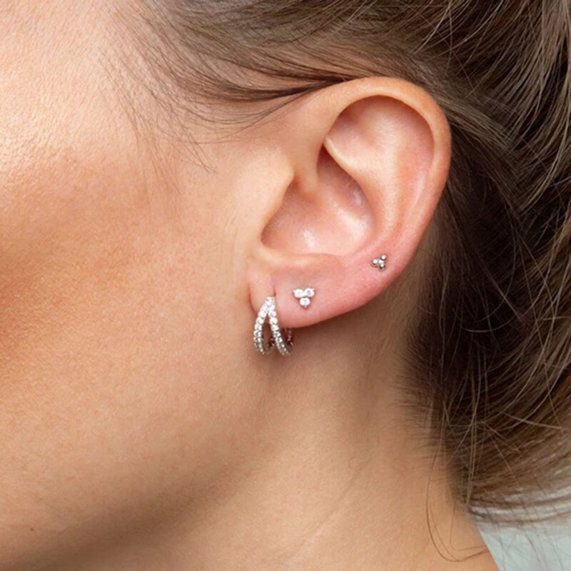 A woman wearing silver Double CZ Huggie Earrings.