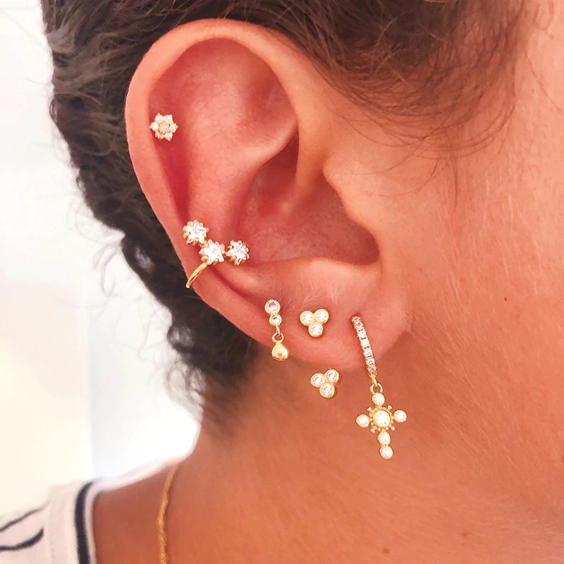 A model wearing the Gold Cross Huggie Earrings with CZ stones.
