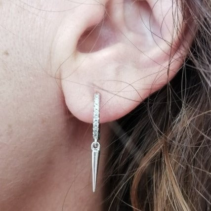 A woman wearing the silver Spike CZ Huggies.