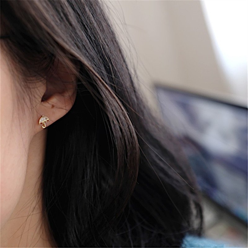 A model wearing the Tiny CZ Umbrella Studs.